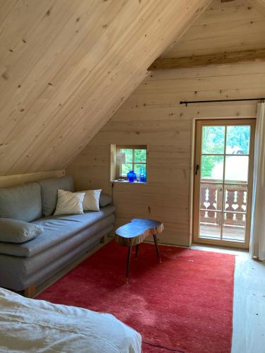 a room with a couch and a table in a attic at Biohof Prem in Sankt Kathrein am Offenegg