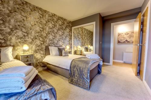 a bedroom with two beds and a mirror at 6 Mariners Point in Hartlepool