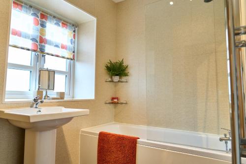 uma casa de banho com um lavatório e uma banheira em 6 Mariners Point em Hartlepool