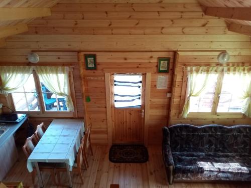 Cabaña de madera con mesa y sofá en Turystyka Mazury Justyna, en Wydminy