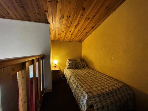 ein kleines Schlafzimmer mit einem Bett und einer Holzdecke in der Unterkunft Résidence Jetay - 3 Pièces pour 7 Personnes 464 in Les Menuires