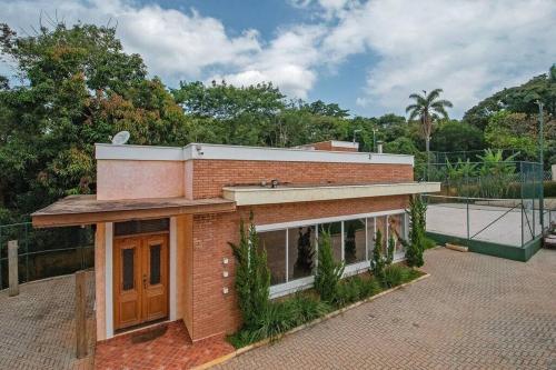 a brick building with a tennis court in front of it at Espaco Bom Viver in Jundiaí
