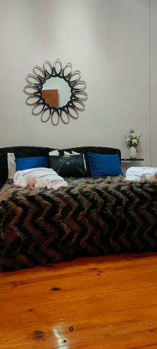 een slaapkamer met een bed met een spiegel aan de muur bij Grand Studios 54 in Faro