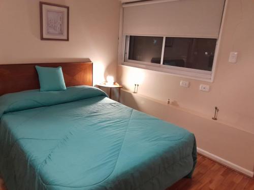 um quarto com uma cama verde e uma janela em Departamento de Gaby en Retiro em Buenos Aires