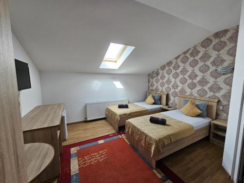 Una pequeña habitación con dos camas y una ventana. en Casa Galu, en Nicoreşti