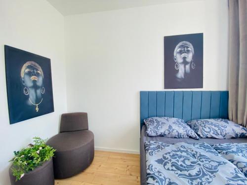 1 dormitorio con 1 cama, 1 silla y fotografías en Family House in Am Schöpfwerk area, en Viena