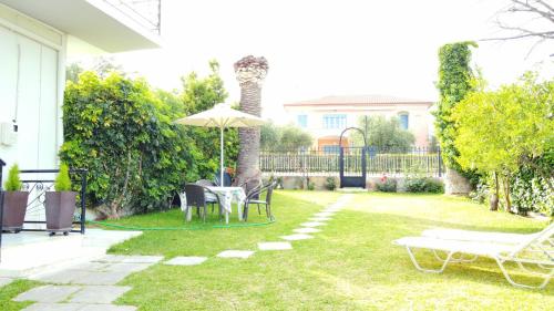 a patio with a table and an umbrella in a yard at Blue Diamond in Chrani