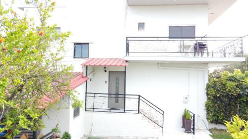 a white house with a balcony with a dog on it at Blue Diamond in Chrani