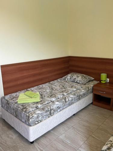 a bed in a room with a wooden head board at Семеен хотел САМИ in Kranevo