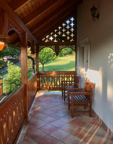 a porch with two chairs and a table on it at ALPHA in Badacsonytördemic