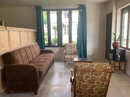 uma sala de estar com um sofá e duas cadeiras em Gîte ferme Saint Gauthier 