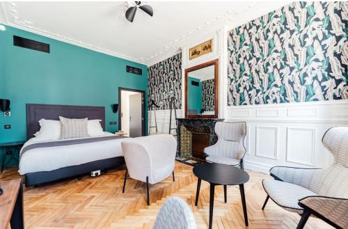 a bedroom with a bed and a blue wall at La villa 10 H&Ocirc;TEL SPA in &Eacute;tretat