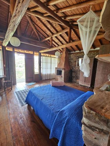 a large bedroom with a blue bed in a building at Chalés Vila Carrancas - Unidade Serra in Carrancas