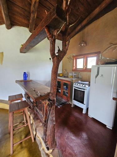a kitchen with a tree in the middle of it at Chalés Vila Carrancas - Unidade Serra in Carrancas