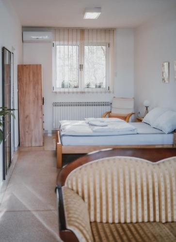 a bedroom with two beds and two windows at MASAL Studio Apartman in Bihać
