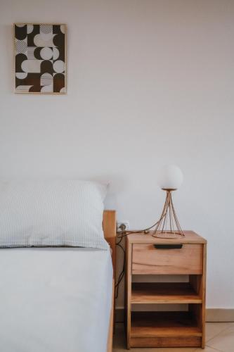 a bedroom with a bed and a table with a lamp at MASAL Studio Apartman in Bihać