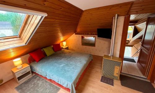 małą sypialnię z łóżkiem w drewnianym pokoju w obiekcie Károly II. Vendégház w Hévízie
