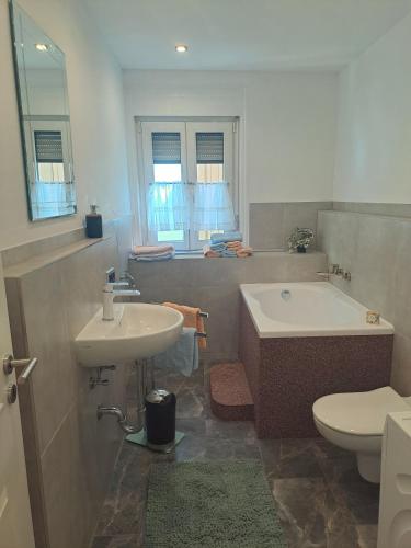 ein Badezimmer mit einem Waschbecken, einer Badewanne und einem WC in der Unterkunft Bopparder Schmuckhäusschen in Boppard