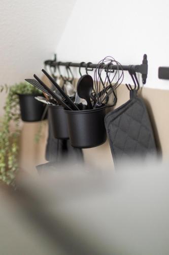 a pot full of utensils hanging on a wall at Soulplace Studioapartment Herten in Herten