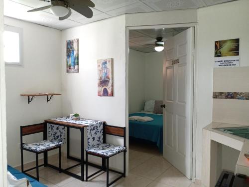 een kamer met een tafel, 2 stoelen en een bed bij Apartamento a 10 minutos Aeropuerto Tocumen in Panama-Stad
