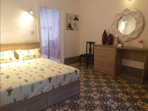 1 dormitorio con 1 cama y vestidor con espejo en Cactus & Mandala en Birżebbuġa
