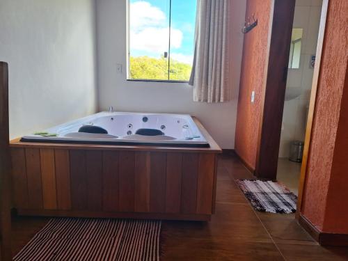 eine Badewanne in einem Zimmer mit Fenster in der Unterkunft SERRA DA NEBLINA in Lavras Novas