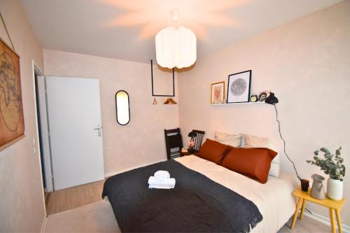 a bedroom with a large bed with a black blanket at Oasis SPA Bath et Jardin Parisien in Aubervilliers