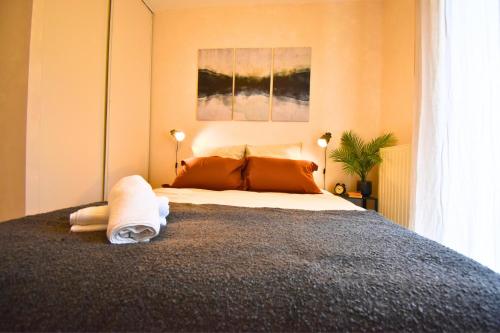a bedroom with a large bed with towels on it at Oasis SPA Bath et Jardin Parisien in Aubervilliers