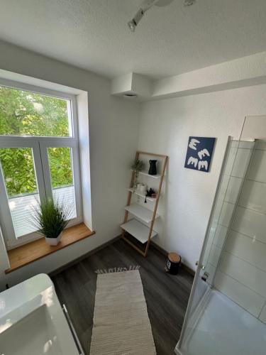 a bathroom with a shower and a sink and a window at FeWo Krabbe in Wilhelmshaven
