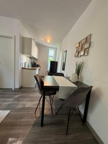 a dining room and kitchen with a table and chairs at FeWo Krabbe in Wilhelmshaven