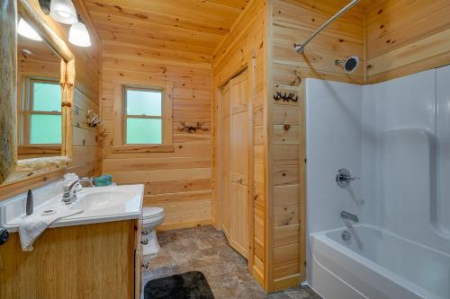 a bathroom with a sink and a toilet and a tub at Private Hot Tub Gatlinburg Cabin in the Clouds in Gatlinburg