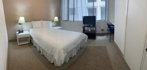 a hotel room with a bed and a television at Walther Suites in Quito