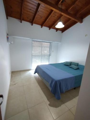 a bedroom with a blue bed and a window at Hermoso Duplex en San Miguel in General Sarmiento