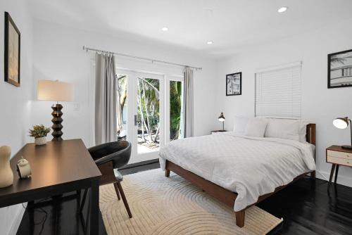 a white bedroom with a bed and a desk at Summer Estate - Pool Parking & Prime Location in Miami