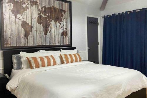 ein Schlafzimmer mit einem großen weißen Bett mit einer Karte an der Wand in der Unterkunft Vacation Home with Private Pool in Dallas