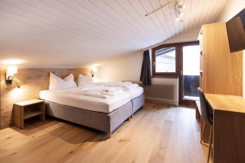 ein Schlafzimmer mit einem großen Bett in einem Zimmer in der Unterkunft Hotel Pinzgauerhof Ski & Bike - Inclusive Joker Card in Saalbach-Hinterglemm