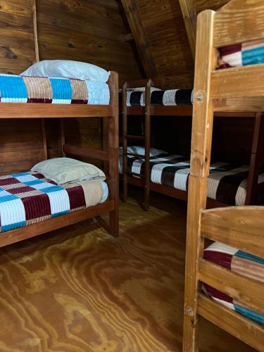 Zimmer mit 3 Etagenbetten in einer Hütte in der Unterkunft Hebes House in Caviahue