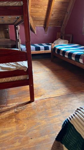 2 Etagenbetten in einem Zimmer mit Holzboden in der Unterkunft Hebes House in Caviahue