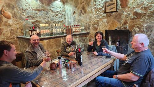 a group of people sitting around a table with wine glasses at KHORGO in Gori