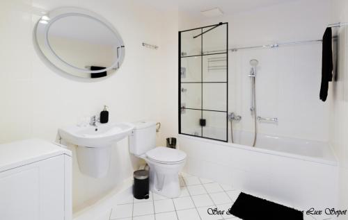 a white bathroom with a toilet and a sink at Sea & City 50 m Monte Casinno 100 m Beach Apartments Lux Sopot in Sopot