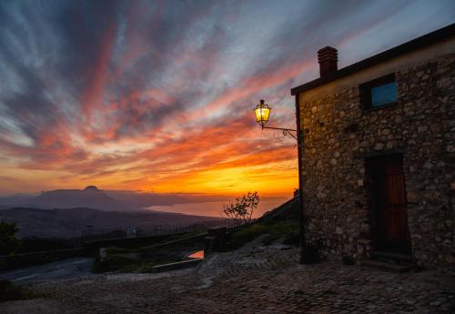 a sunset with a building and a street light at Case Ruggieri Luxury apt - Don Pietro in Gratteri