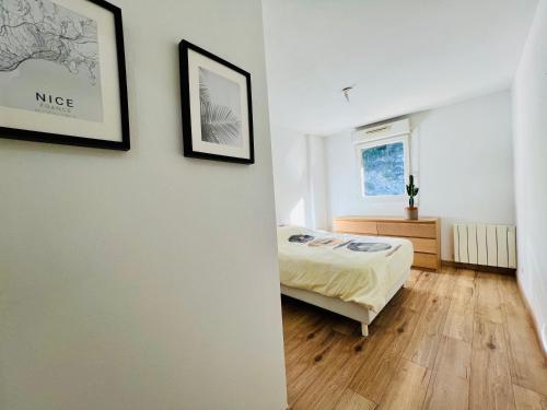 une chambre avec un lit et deux tableaux au mur dans l'établissement Magnificent renovated apartment, 2 rooms of 45 m2, close tothe sea, top floor, terrace, à Nice