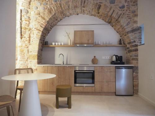 een keuken met een tafel en een bakstenen muur bij enδόtera chios apartments in Chios