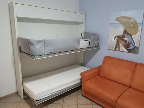 a living room with a couch and a chair at Appartamento in centro a 30m dal mare in Spotorno