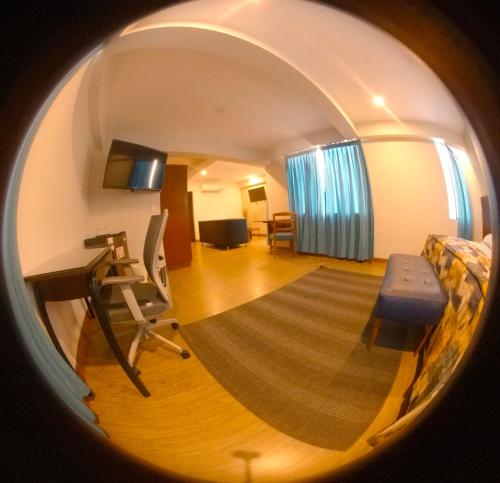 Habitación redonda con escritorio y silla en Hotel Esencia Suites, en Lima