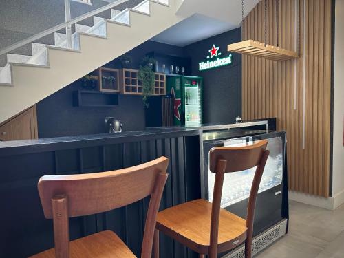 a bar with two chairs and a tv and stairs at DM HOTEL in Propriá