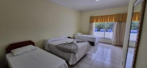Habitación de hotel con 2 camas y ventana en Capão Praia Hotel, en Capão da Canoa