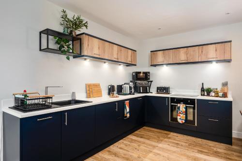 cocina con armarios azules y encimera en Coach House by Coppergate Grimsby, en Great Coates