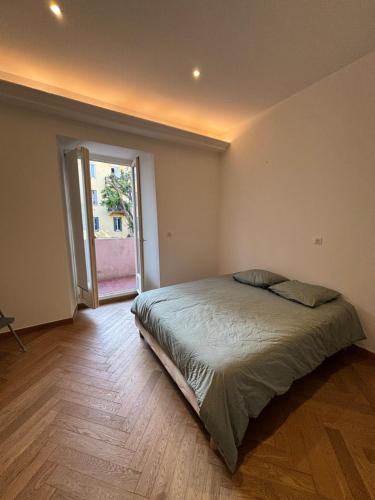 une chambre avec un grand lit dans une pièce dans l'établissement Appartement Ajaccio hyper centre, à Ajaccio