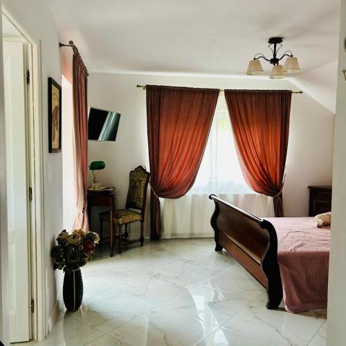 a bedroom with a bed and a window with red curtains at Pensiunea DolceVita in Măldăreşti